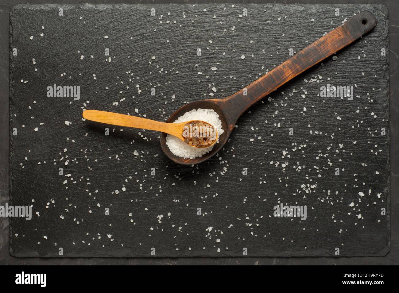brown sugar and salt in wooden spoon on dark background. Flat lay. Stock Photo