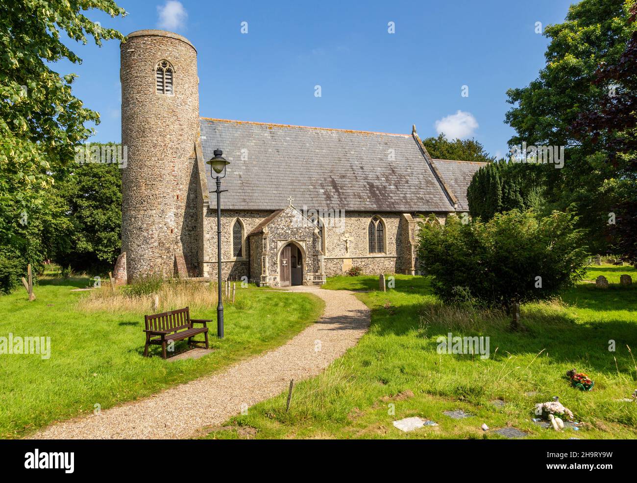 Gravestones in churchyard round tower of church of St John the Baptist, Lound, Suffolk, England, Stock Photo