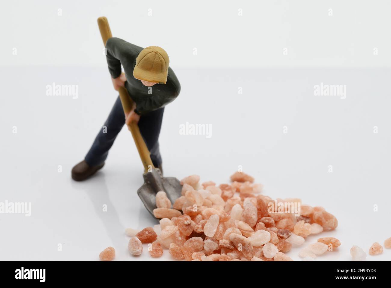 Model workman shovelling pink and white rock salt Stock Photo - Alamy