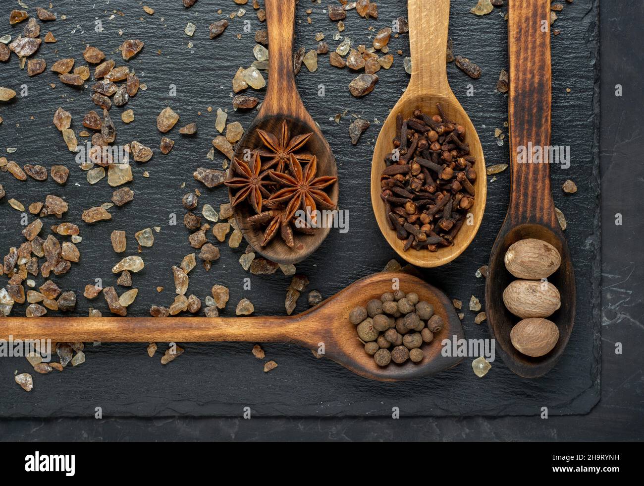 Mix of spices nutmeg, cinnamon, star anise, cloves and cardamom on dark slate background. Flat lay or top view Stock Photo