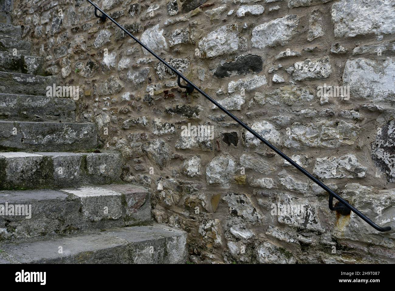 Greek Stone Railing Antique stone steps against a handcrafted stone wall with a wrought ...