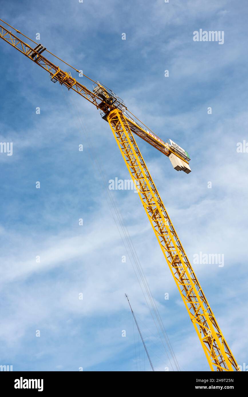 Yellow tower crane against a blue sky Stock Photo