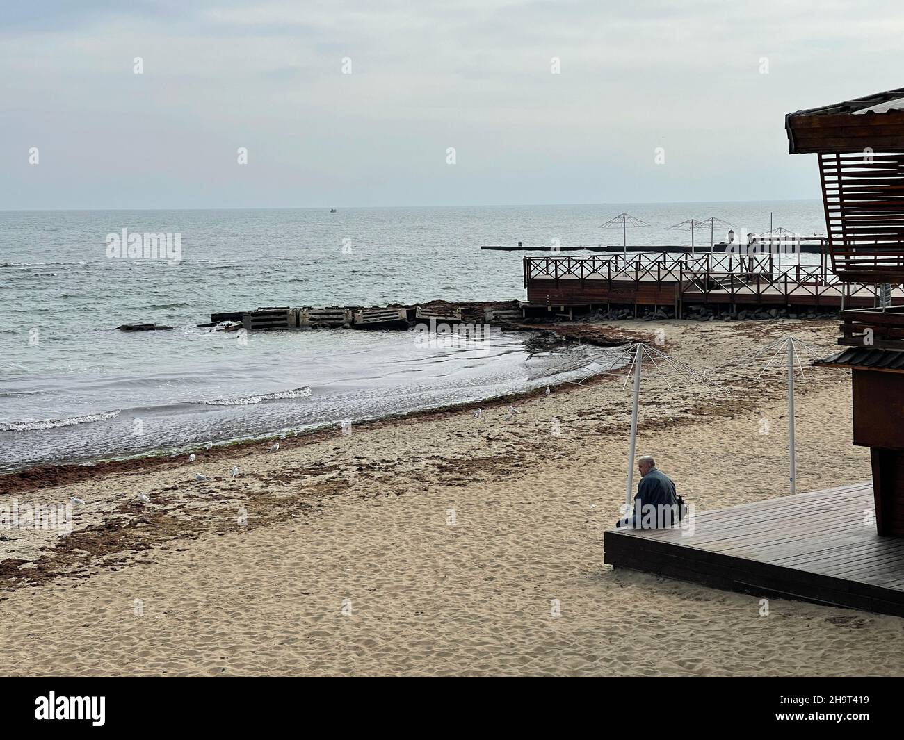 Unrecognizable old man sitting alone on the beach Stock Photo - Alamy