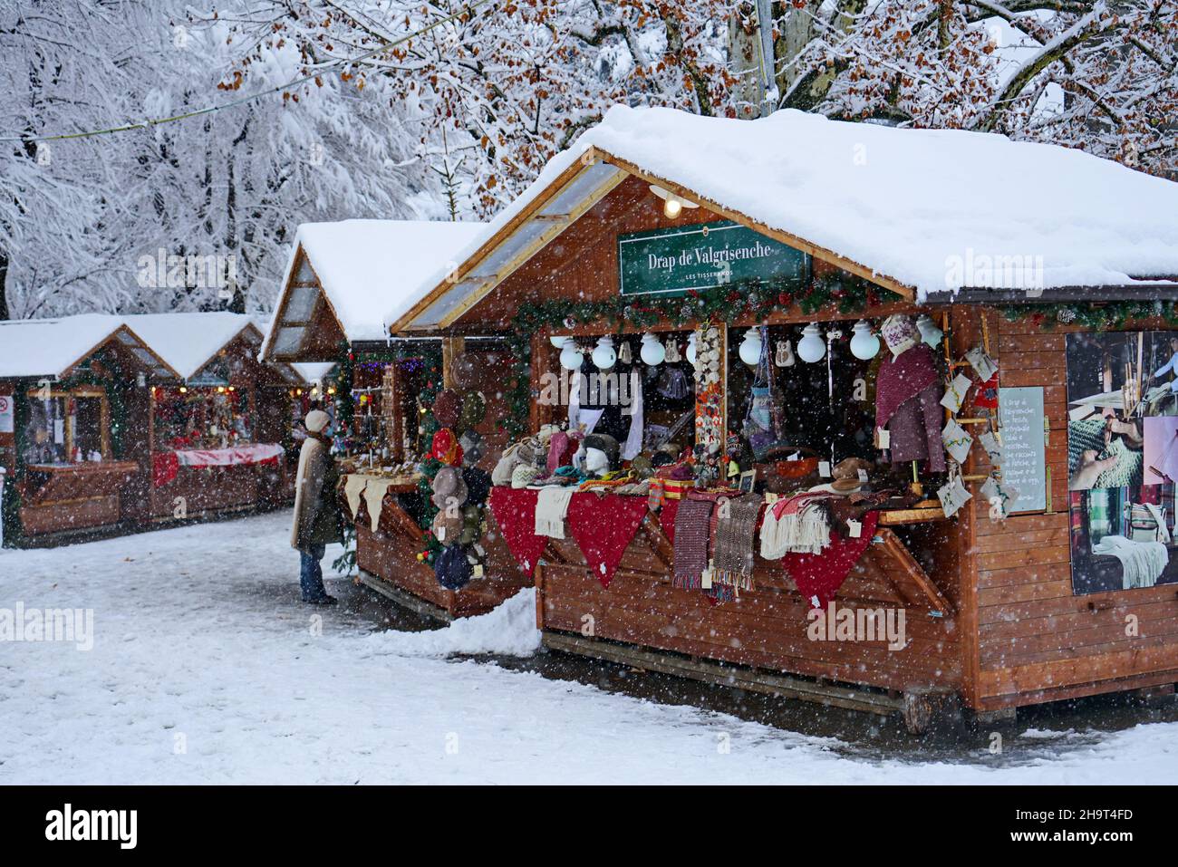 Traditional Christmas market under heavy snowfall. Aosta, Italy -December 2021 Stock Photo