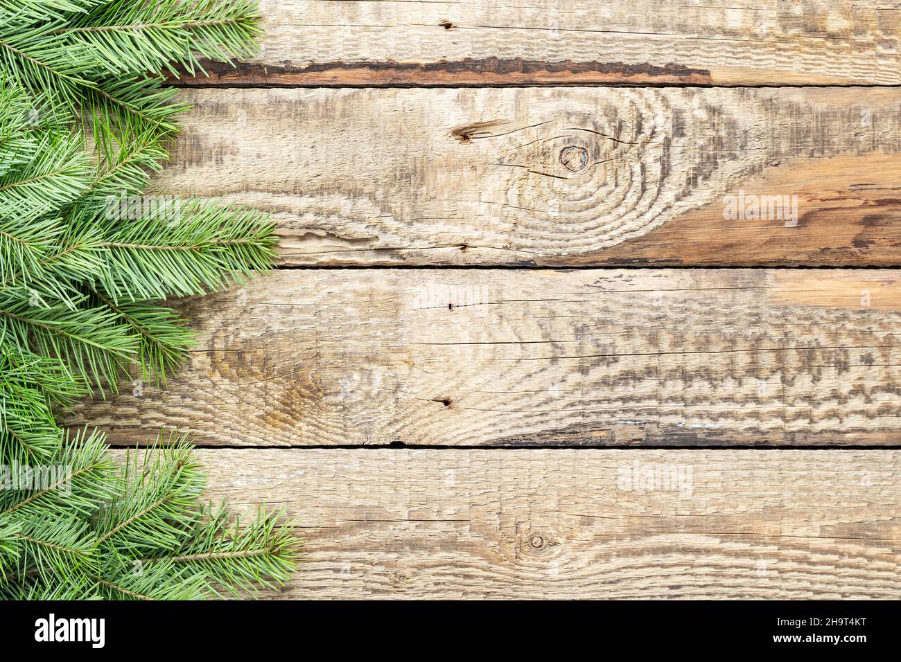 Christmas tree green branches on a wooden background. Decorations for Christmas and New Year. Top view, copy space Stock Photo