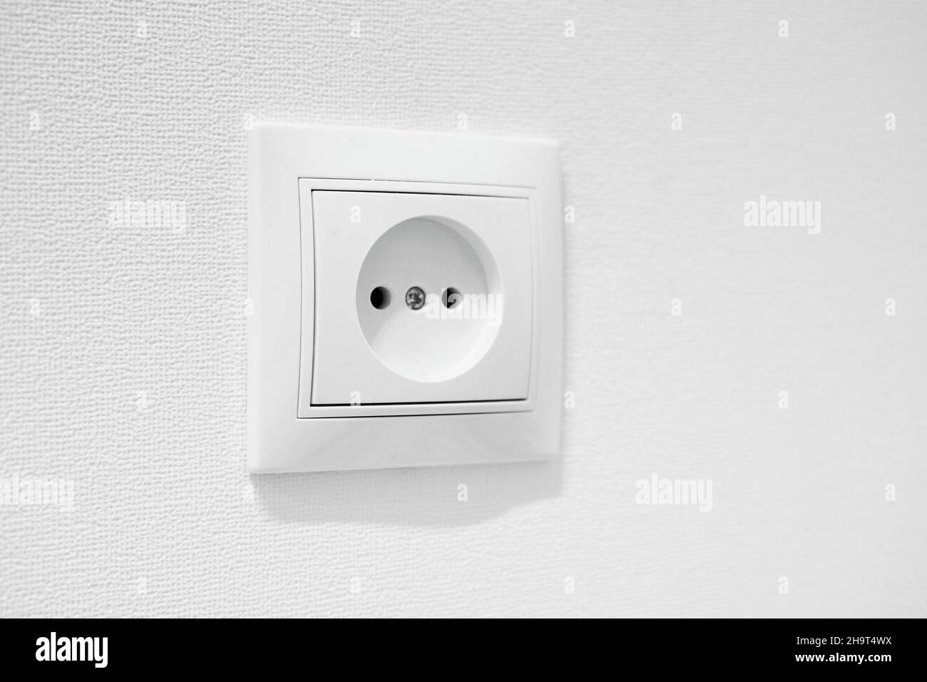 German circular recess socket with two round holes for 2 pins europlugs types C, E and F. Common cheap plastic AC power wall outlet. Not grounded Stock Photo