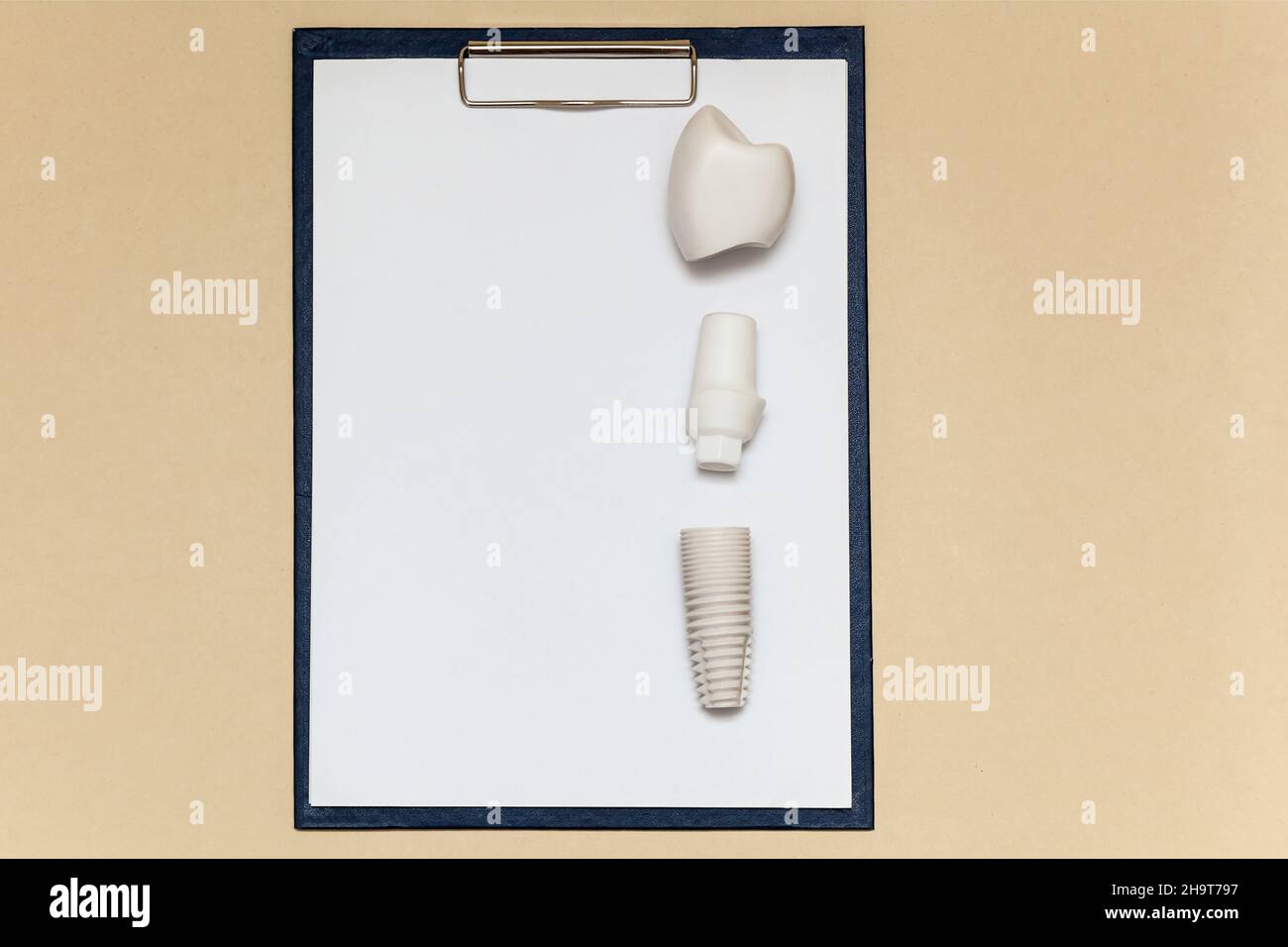 Dental implant and folder with clip for paper sheets A4 on beige
