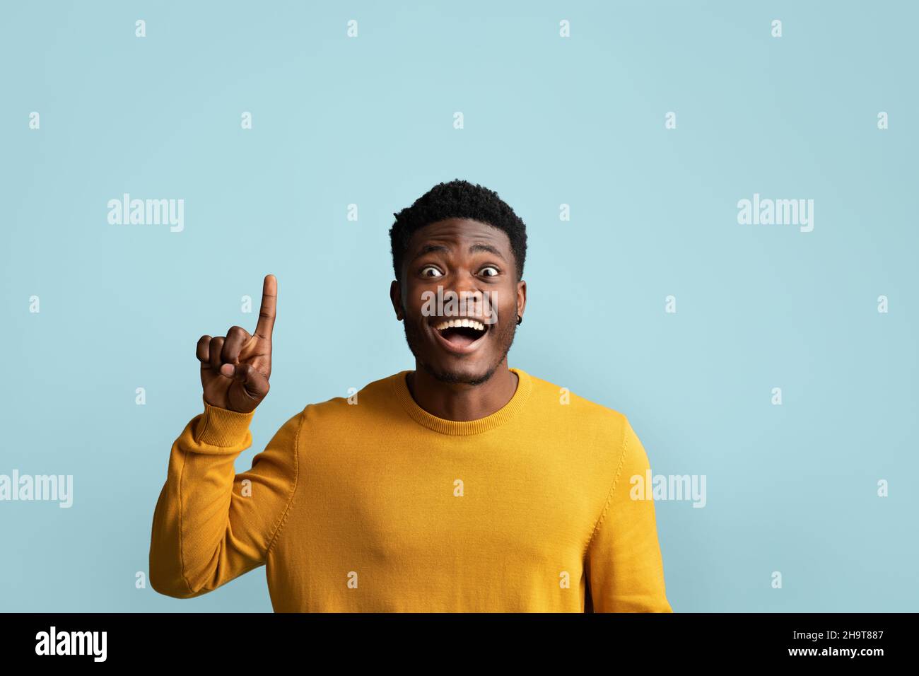 Excited african american guy pointing finger up Stock Photo