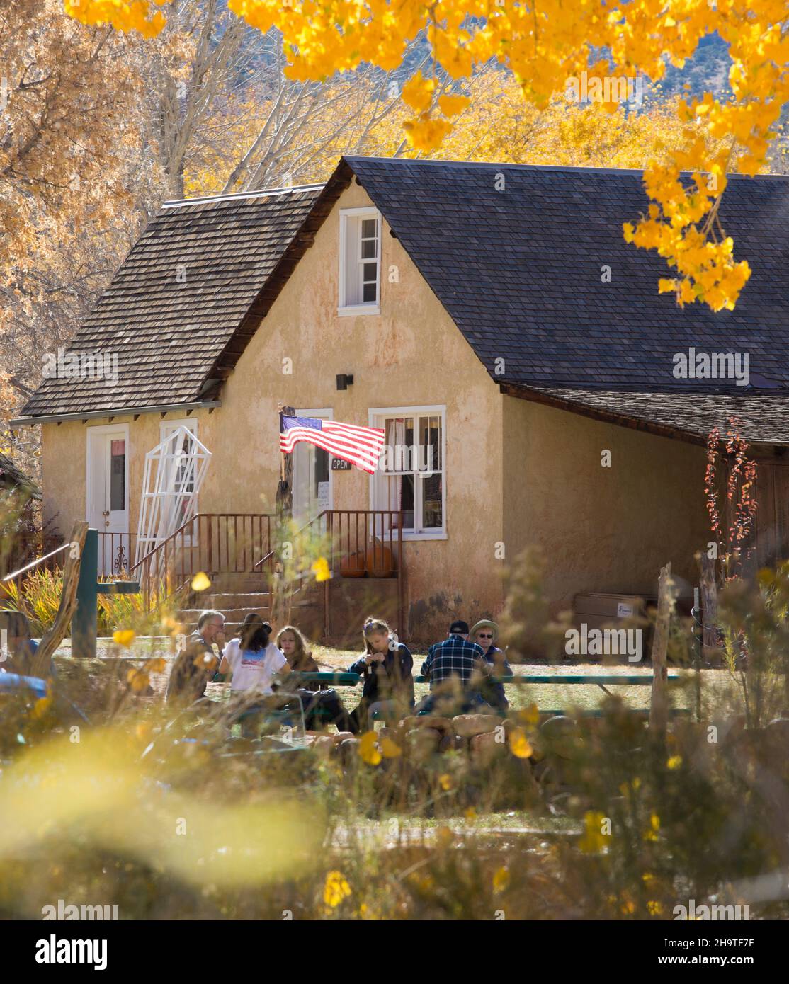 Fruita, Capitol Reef National Park, Utah, USA. Visitors relaxing in the gardens of Gifford House, part of the historic Gifford Homestead, autumn. Stock Photo