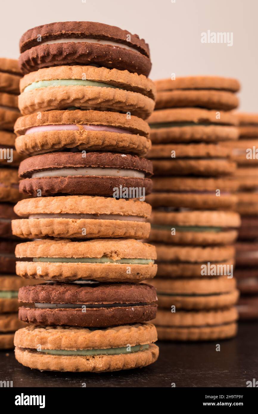 Different cookies one on top of the other on a black wooden table Stock Photo