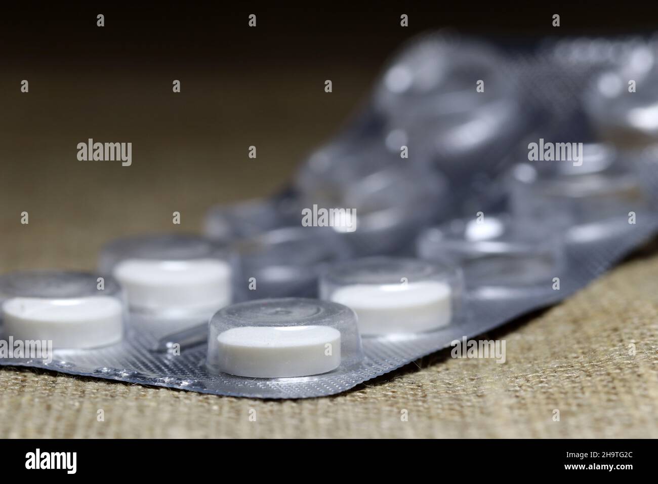 Pills in blister on blurred  background. Closeup. Stock Photo