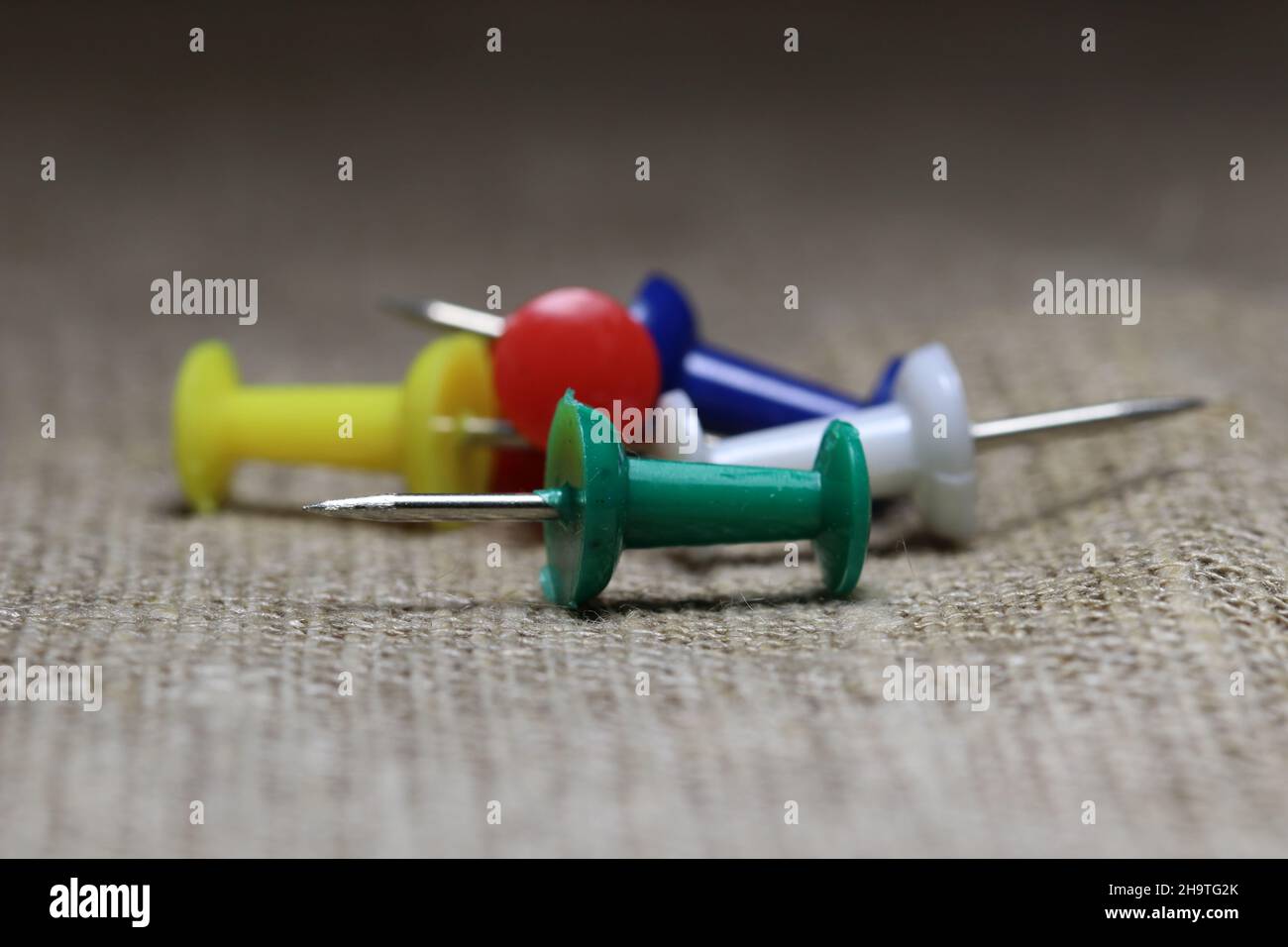 View of a bunch of colored stationery buttons on a blurred background. Stock Photo