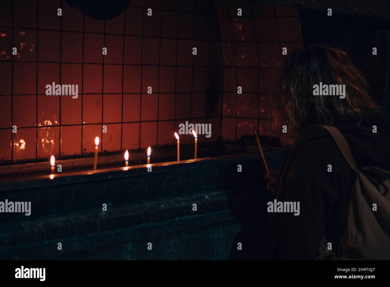 Girl lighting a candle in the church. Praying candles Stock Photo Alamy