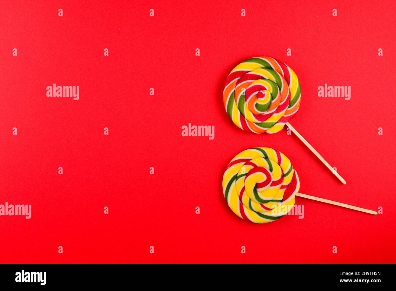 Colorful candy on a red background. Lollipop. Top view. Copy space