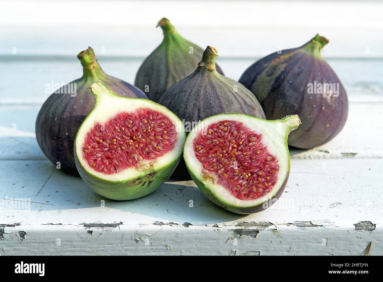 fig (Ficus carica), five figs, one of them halved Stock Photo