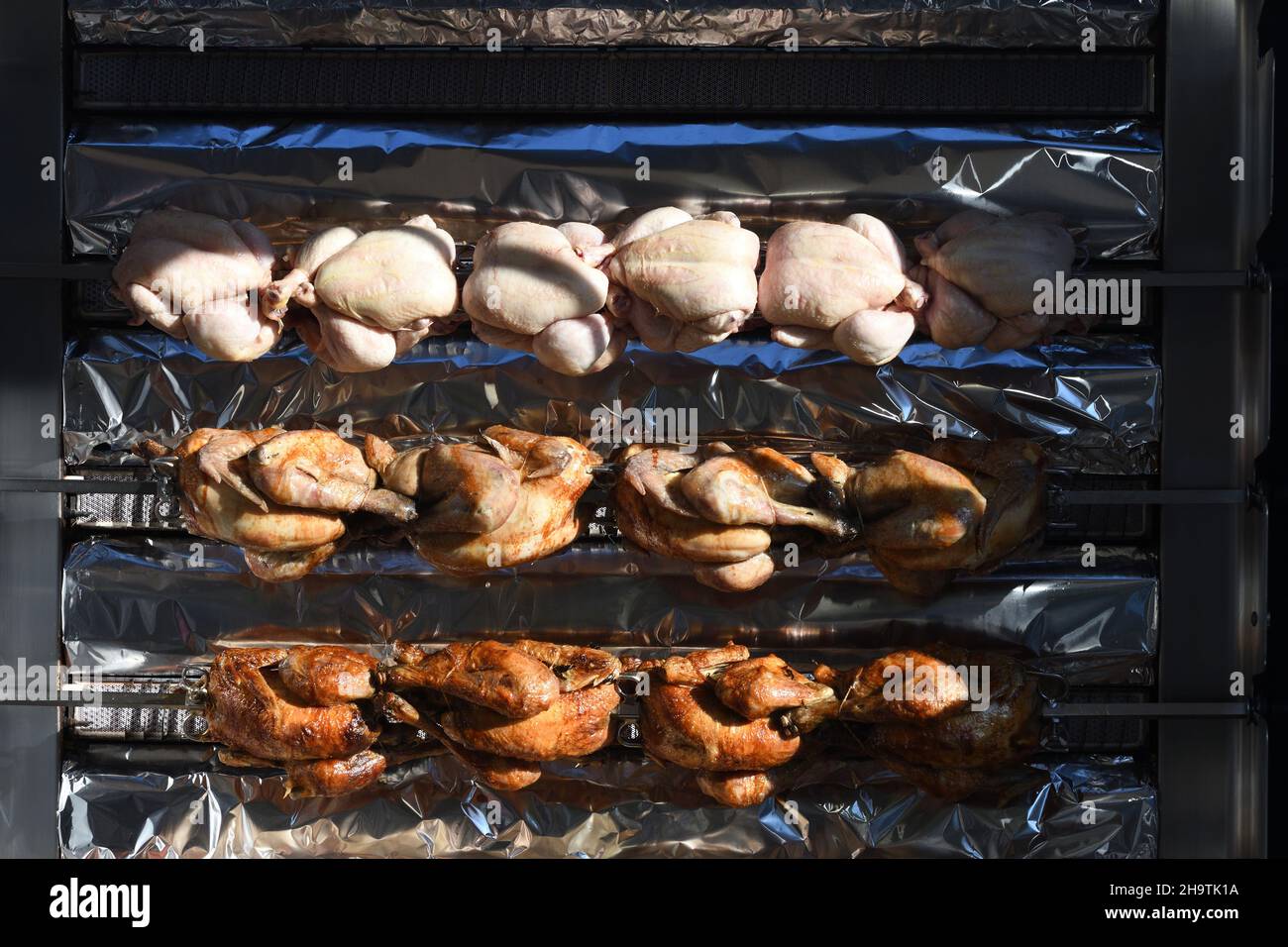 domestic fowl (Gallus gallus f. domestica), rotisserie chicken cooking on a horizontal rotisserie, chicken grill, France, Brittany, Département Stock Photo