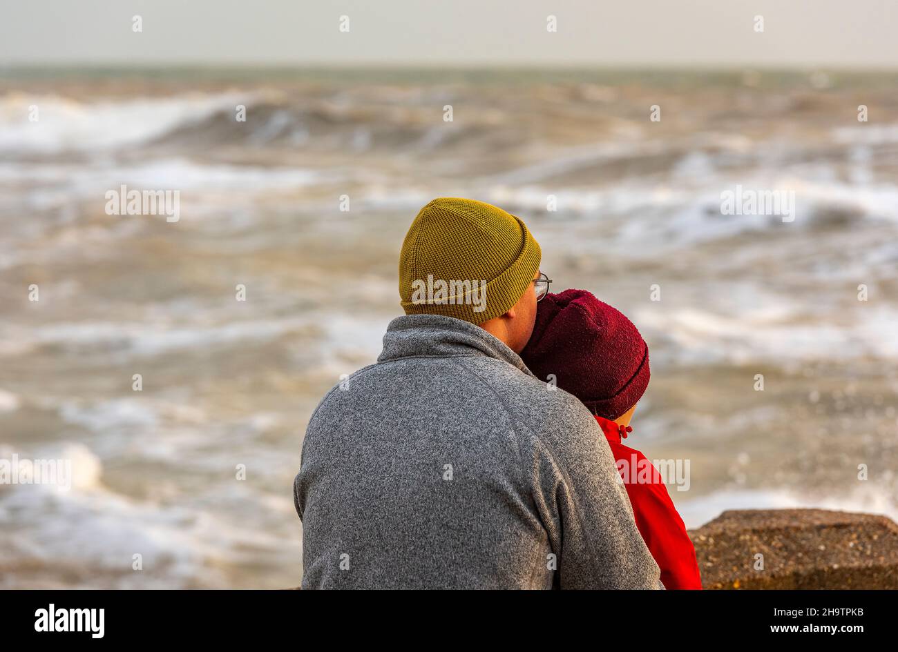 young couple hugging, man and woman cuddling, couple watching a stormy ...