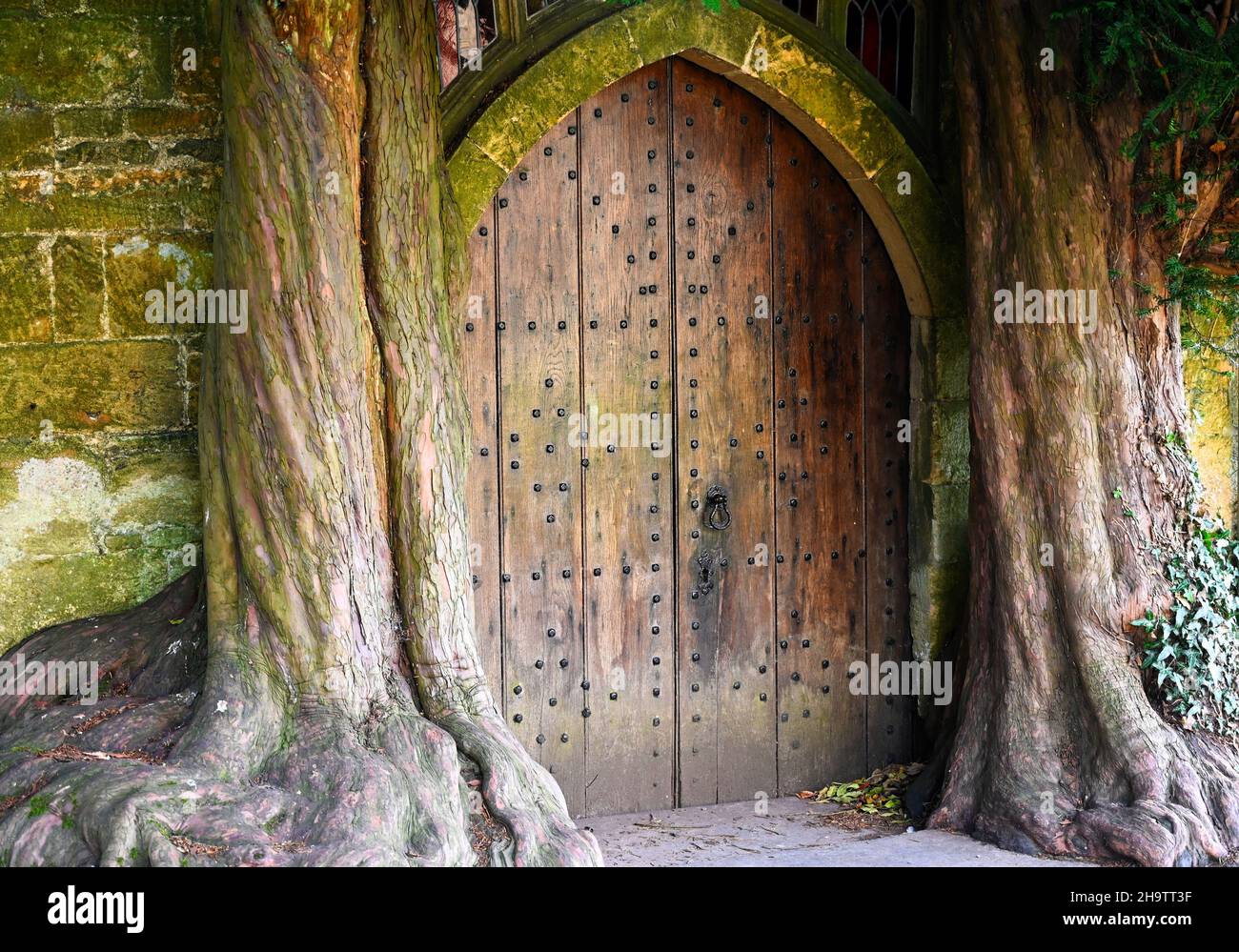 Mystical doorway in historic St Edward's Church in Stow-on-the-Wold. Wooden door looks like a portal. Stock Photo