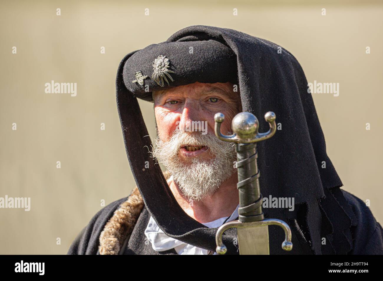 Old man with grey beard holding sword Stock Photo