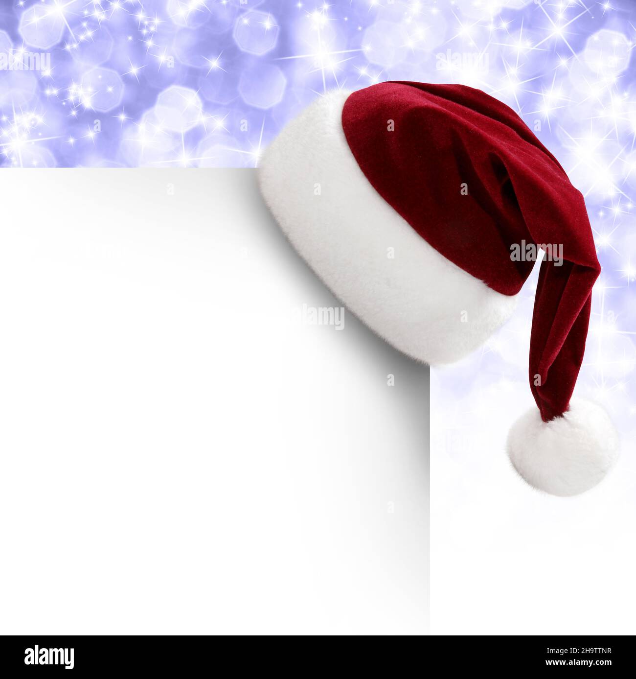 Weihnachtsmütze auf einer Grusskarte zu Weihnachten Stock Photo