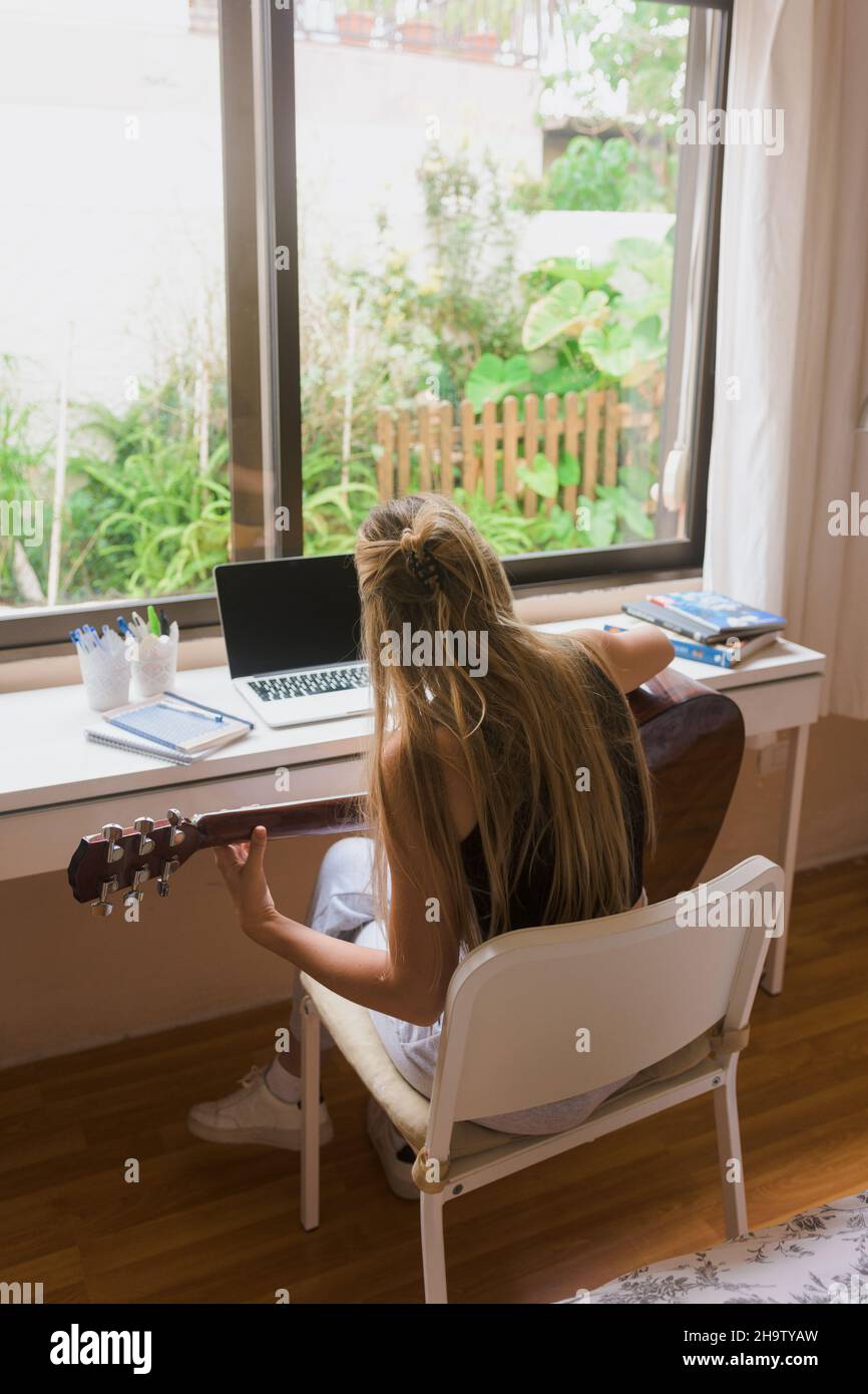 Girl learning guitar in her room. Stock Photo
