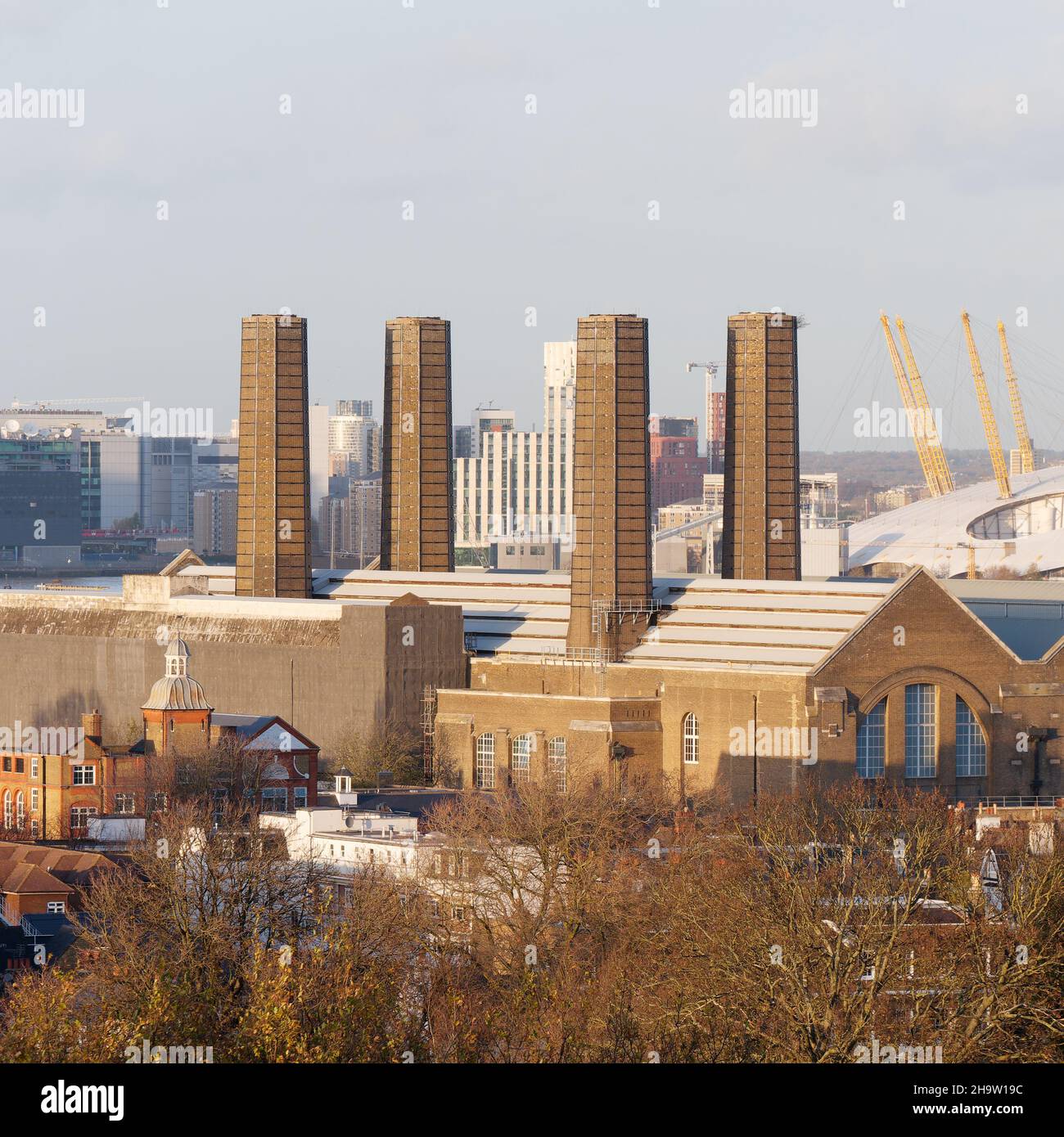 London, Greater London, England, December 04 2021: Building with four distinctive chimneys in Greenwich with the O2 building behind. Stock Photo