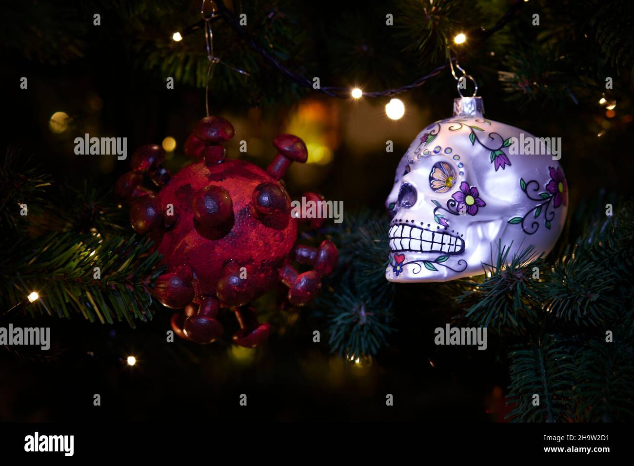 ornaments of a virus and a skull as symbol of impact of covid-19 on xmas season Stock Photo