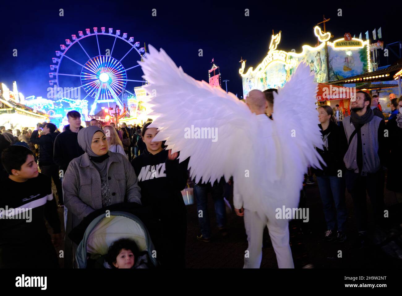 '31.10.2021, Germany, Bremen, Bremen - Young man with angel costume at Bremen open air market. The popular fair is scaled down because of Corona and w Stock Photo