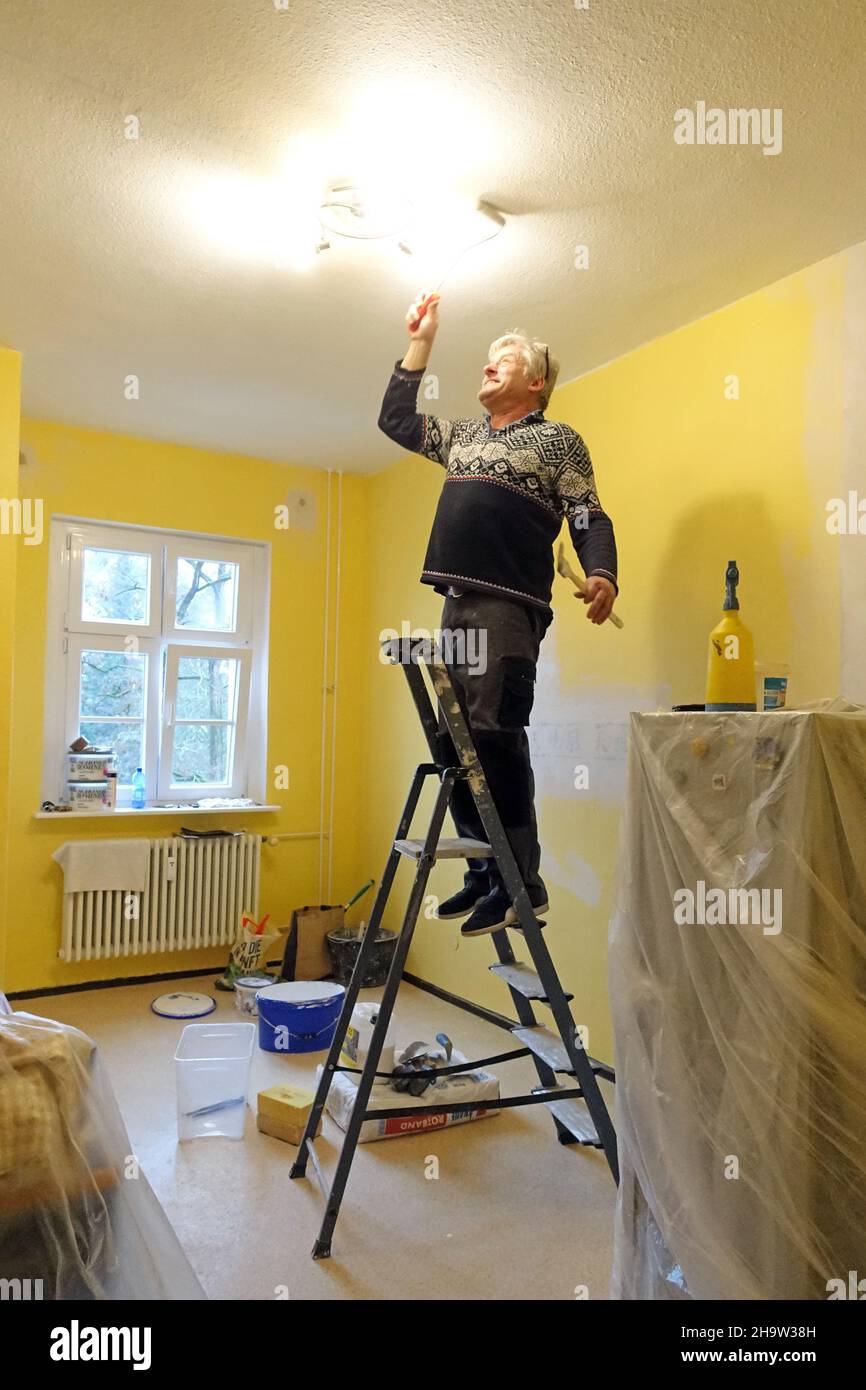 "04.02.2021, Germany, , Berlin Man painting the kitchen ceiling in