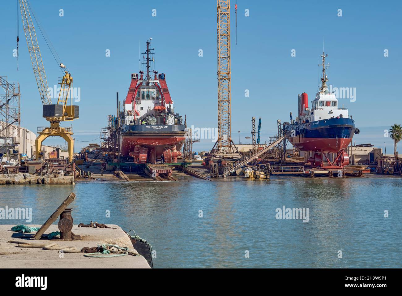 two boats repairing the tug boat in dry dock in the port of Burriana, Castellon, Spain, Europe Stock Photo