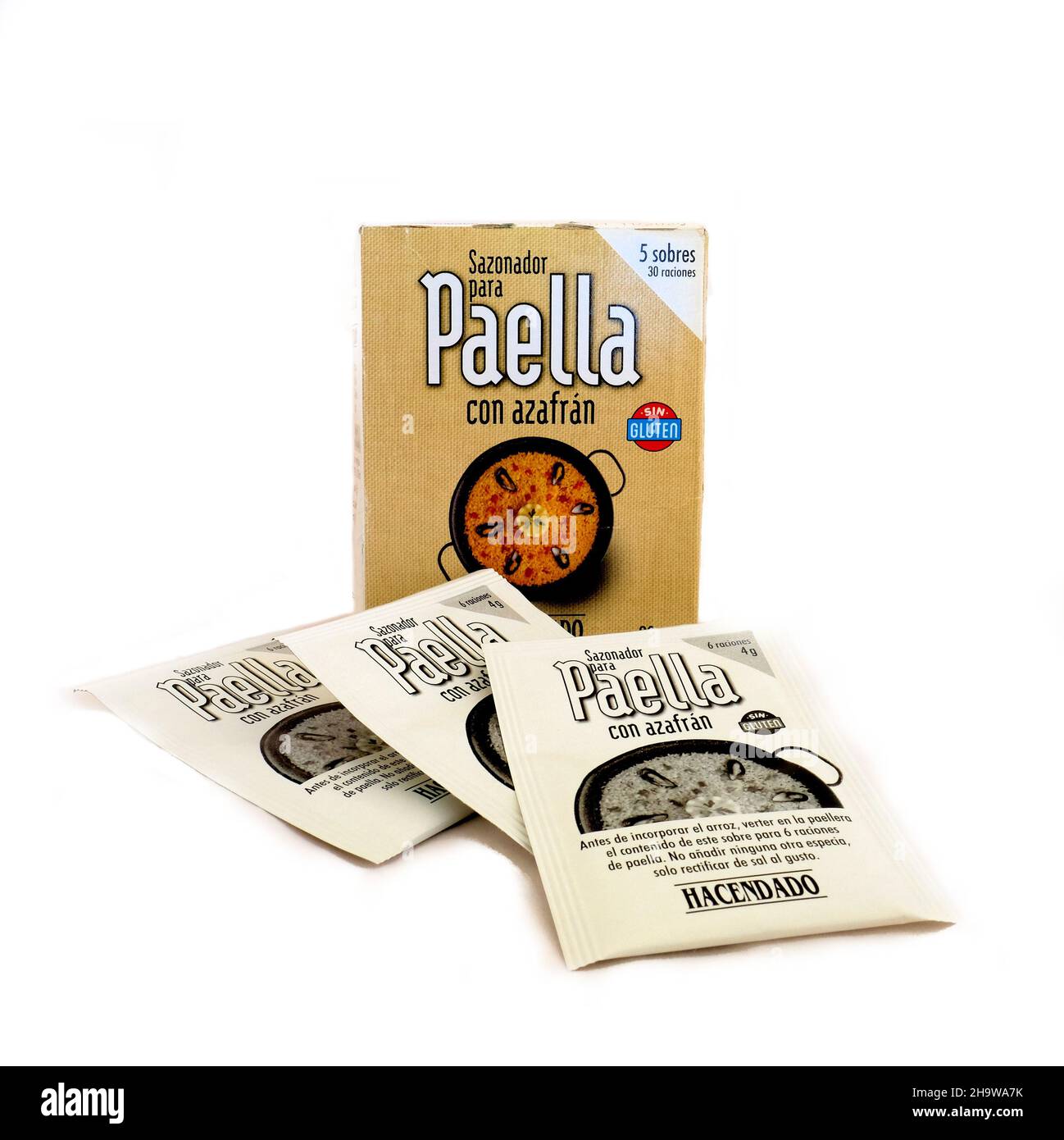 Hacendado brand Spanish paella seasoning mix with saffron with three spice packs in front on a white background; Spanish ingredients and cooking. Stock Photo