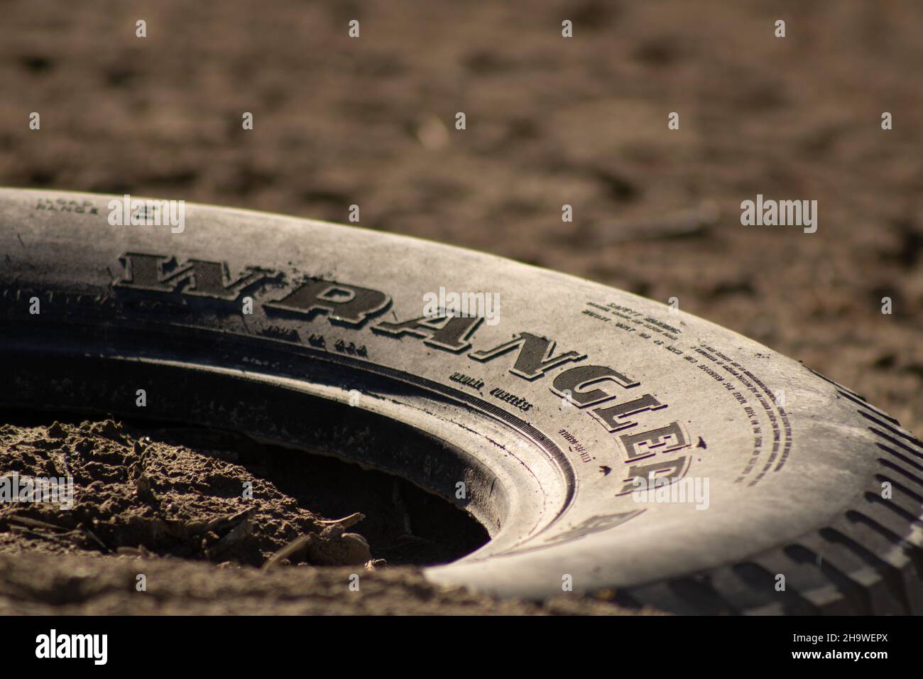 Wrangler Good year tire in dirt dumped in environment Stock Photo