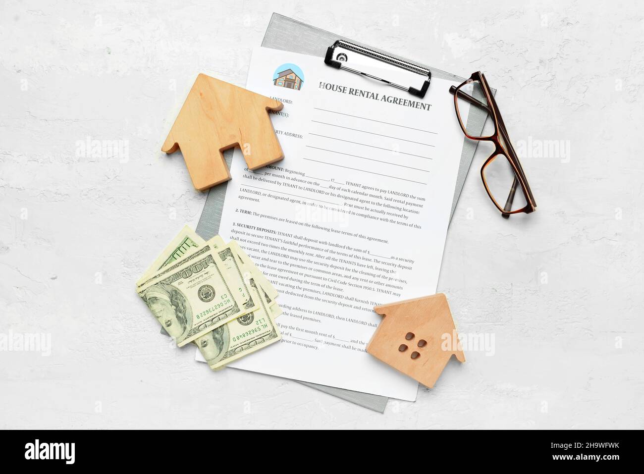 House rental agreement with banknotes, eyeglasses and wooden toys on