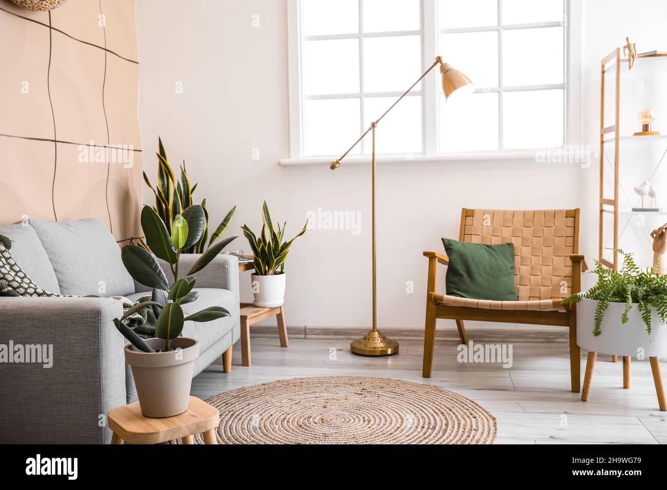 Interior of light living room with armchair and golden standing lamp ...