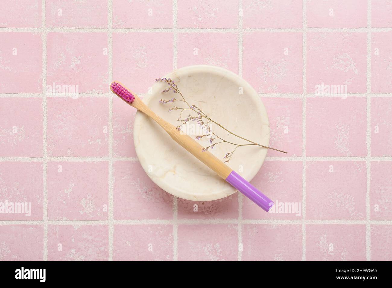 Wooden brush and flower on color background Stock Photo - Alamy