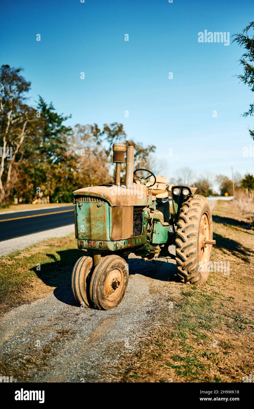Antique or vintage green John Deere tractor on the side of the road in rural Pike Road Alabama, USA. Stock Photo