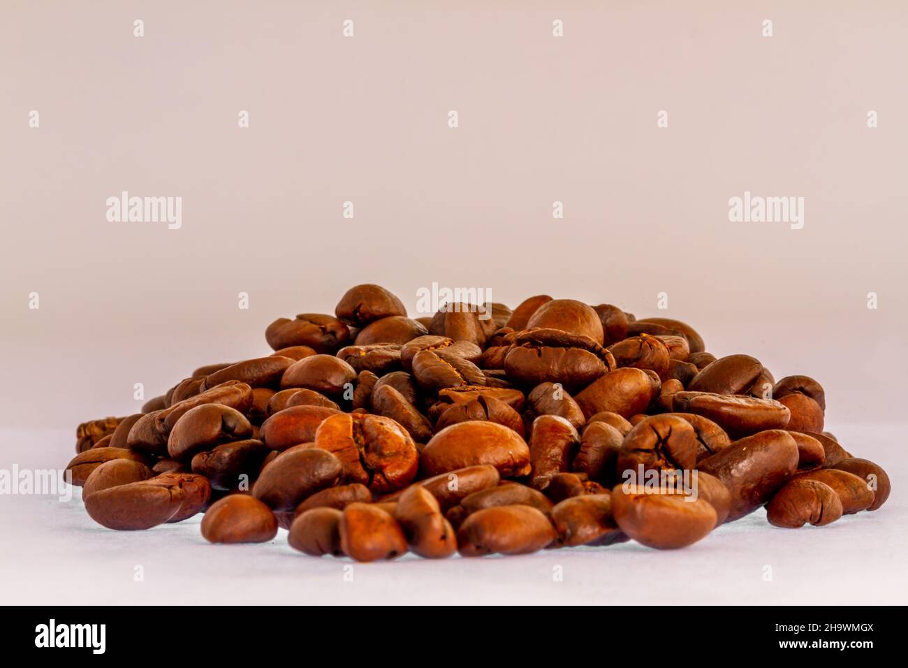 A group of roasted coffee beans, fresh brown in color, ready to be