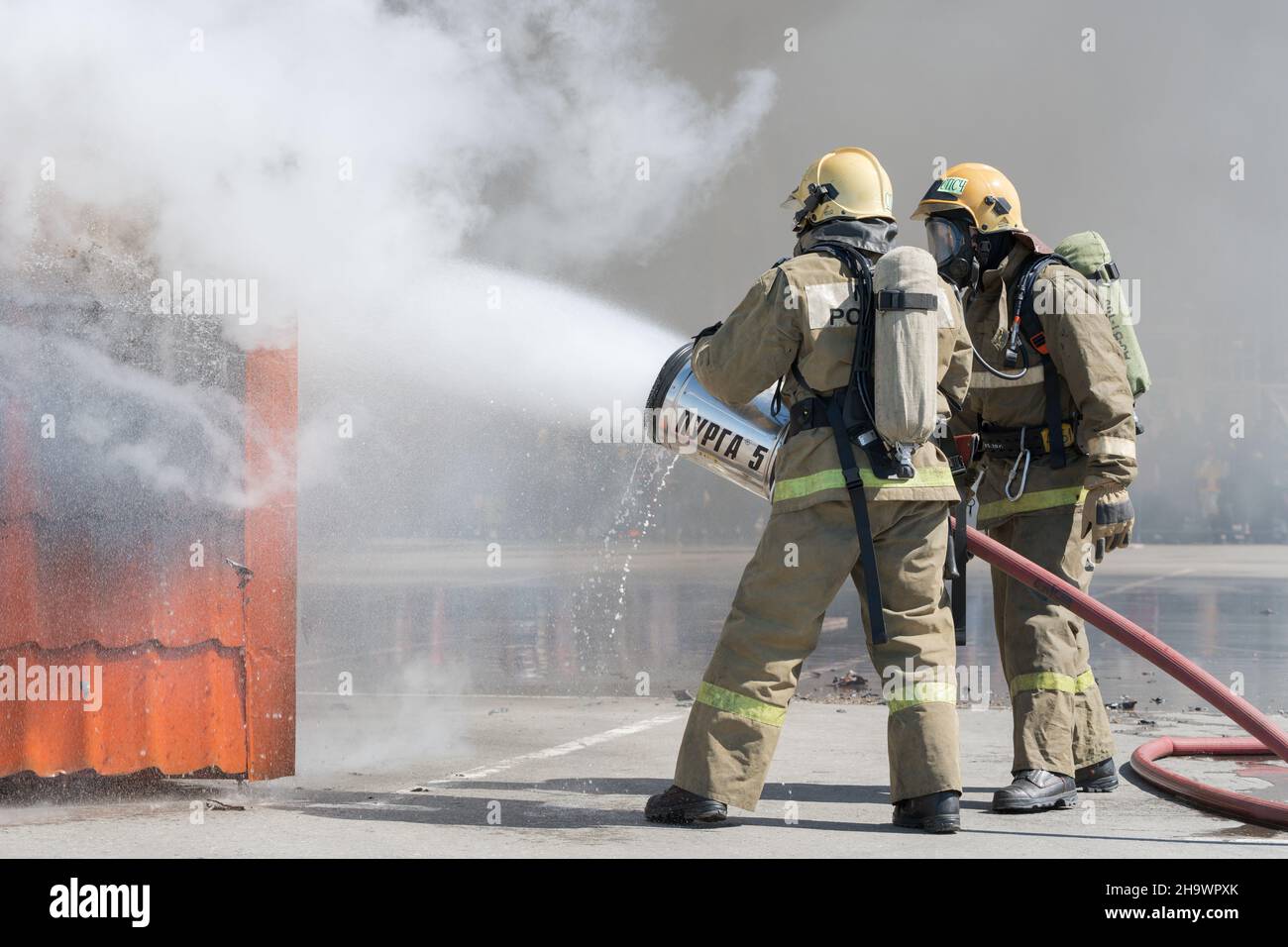 Firefighters extinguishes fire from fire hose, using firefighting water ...