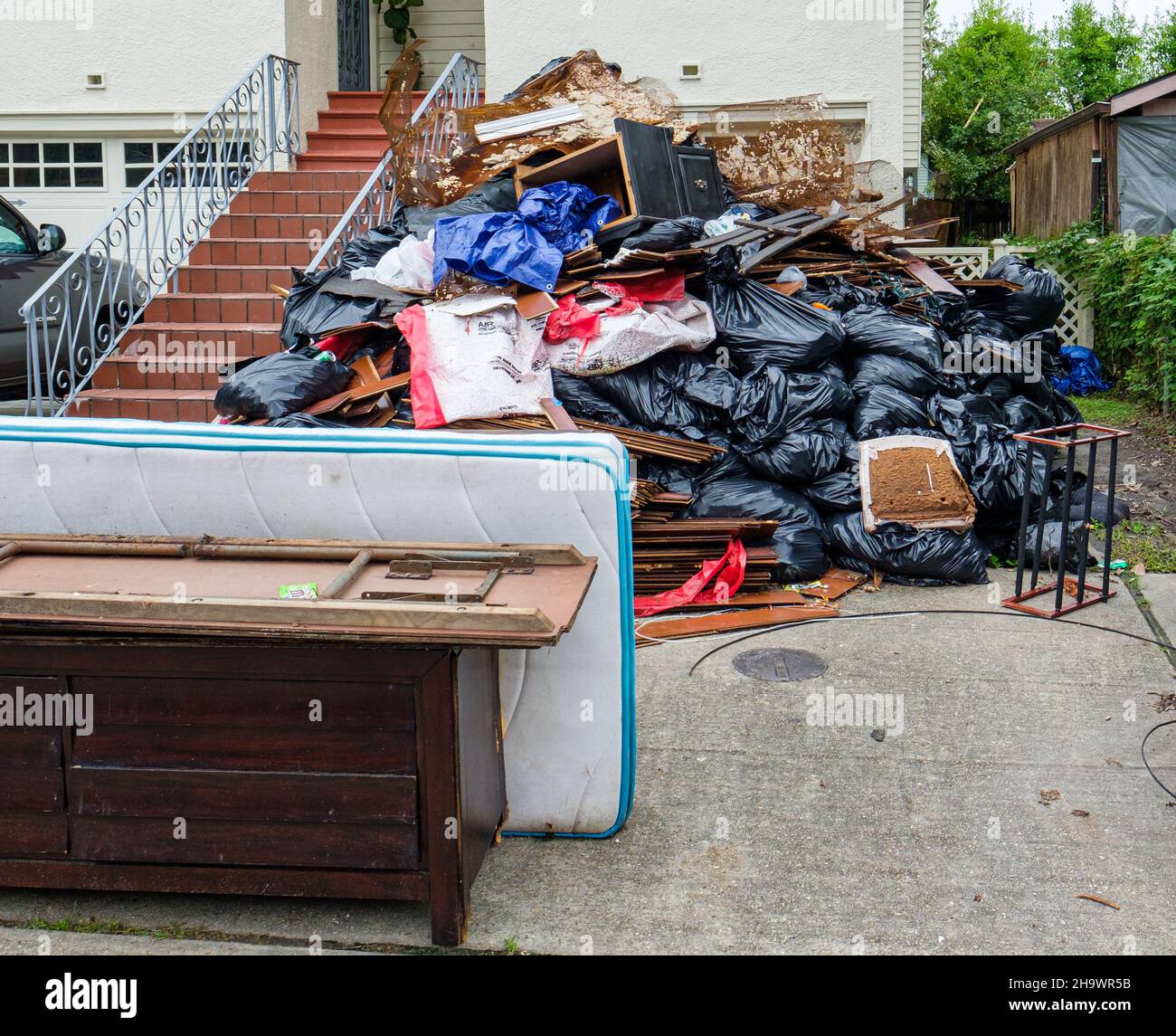 NEW ORLEANS, LA, USA -SEPTEMBER 22, 2021: Mountain of debris in front of house from cleanup of Hurricane Ida's wrath Stock Photo