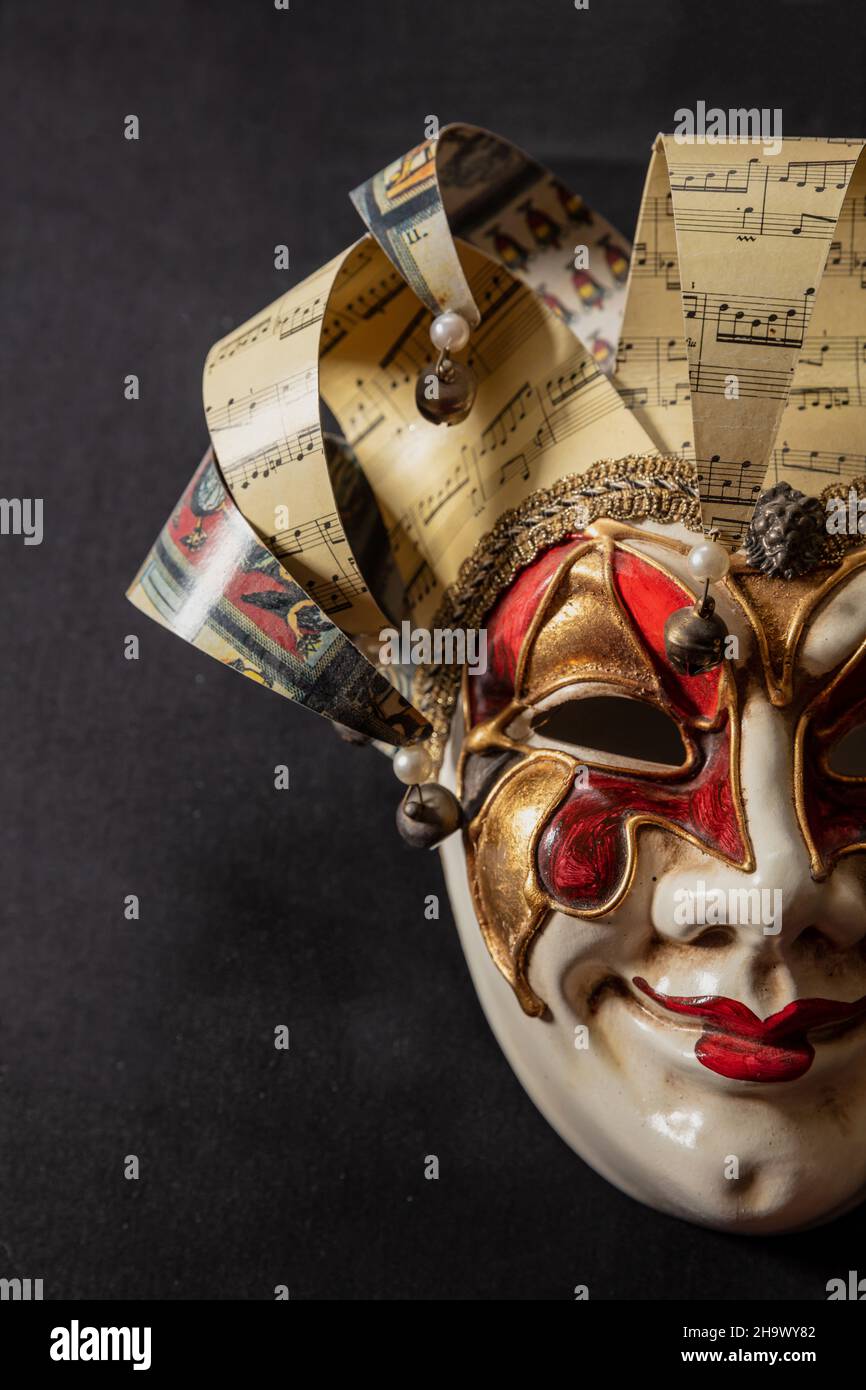 Carnival Venetian harlequin mask on black color background. Italian