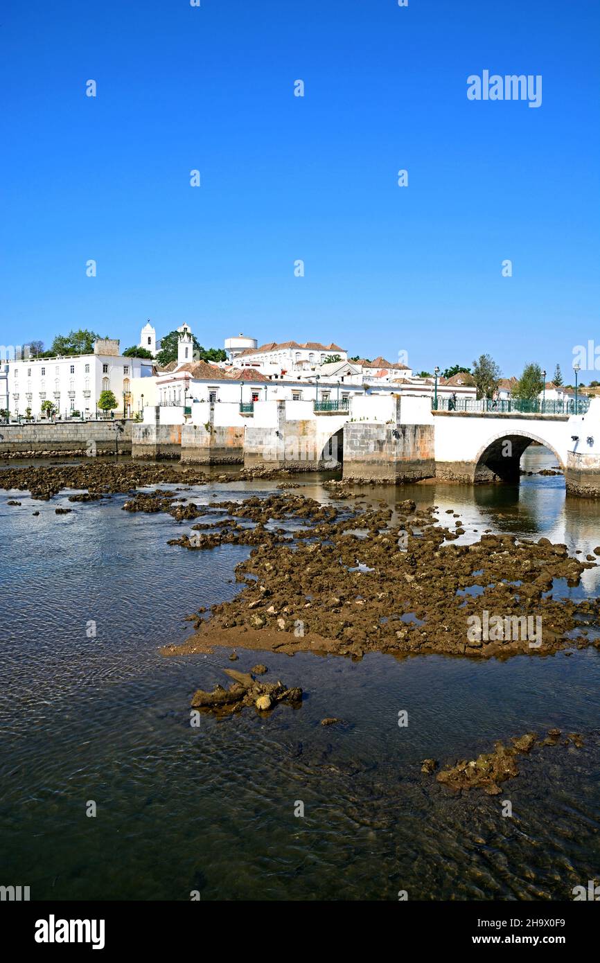 View of the Roman bridge (Ponte Romano) and Gilao river with town buildings to the rear, Tavira, Algarve, Portugal, Europe. Stock Photo