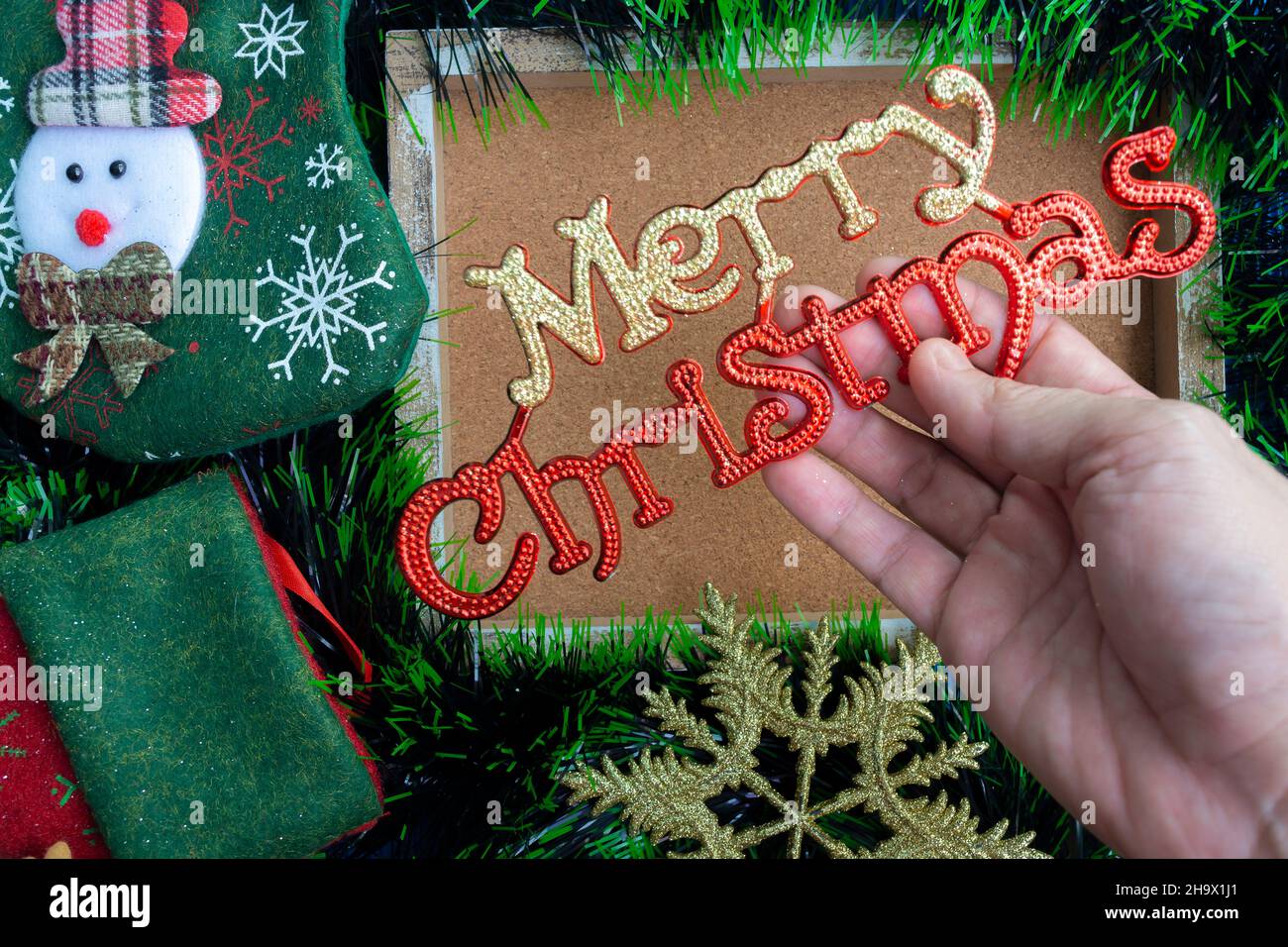 Hand holding Christmas decoration with background of fir tree and ...
