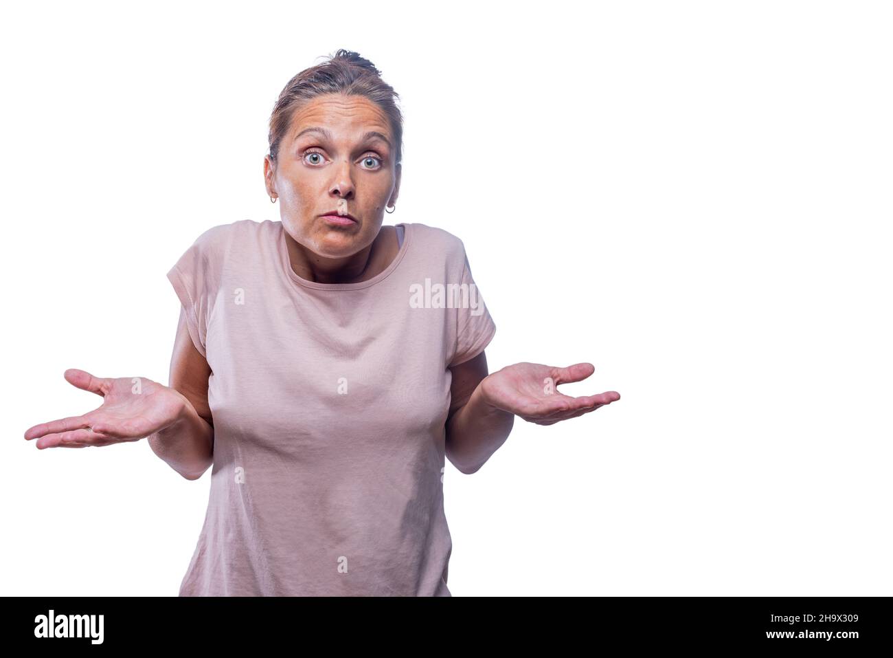 An adult woman looks doubtfully on a white background Stock Photo