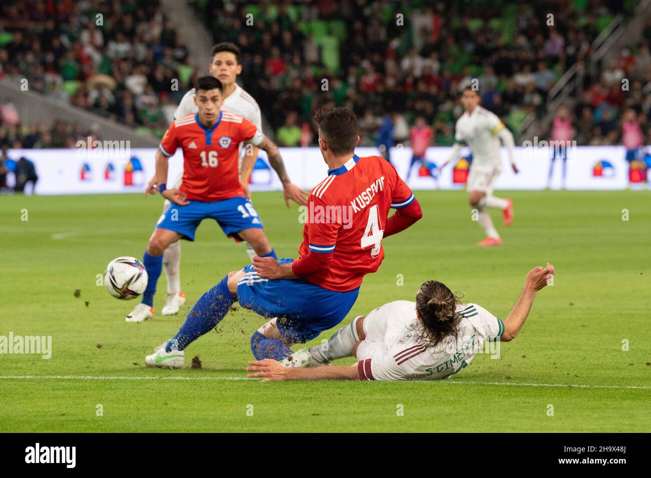 Austin, Texas, USA. 8th December, 2021. Mexico's SANTIAGO GIMENEZ (9) slides under BENJAMIN KUSCEVIC (4) of Chile during the first half of a Mexico National Team vs. Chile friendly at Austin's Q2 Stadium. The teams were tied, 2-2 after regulation play. At left is #16 CLAUDIO BAEZA of Chile. Credit: Bob Daemmrich/Alamy Live News Stock Photo