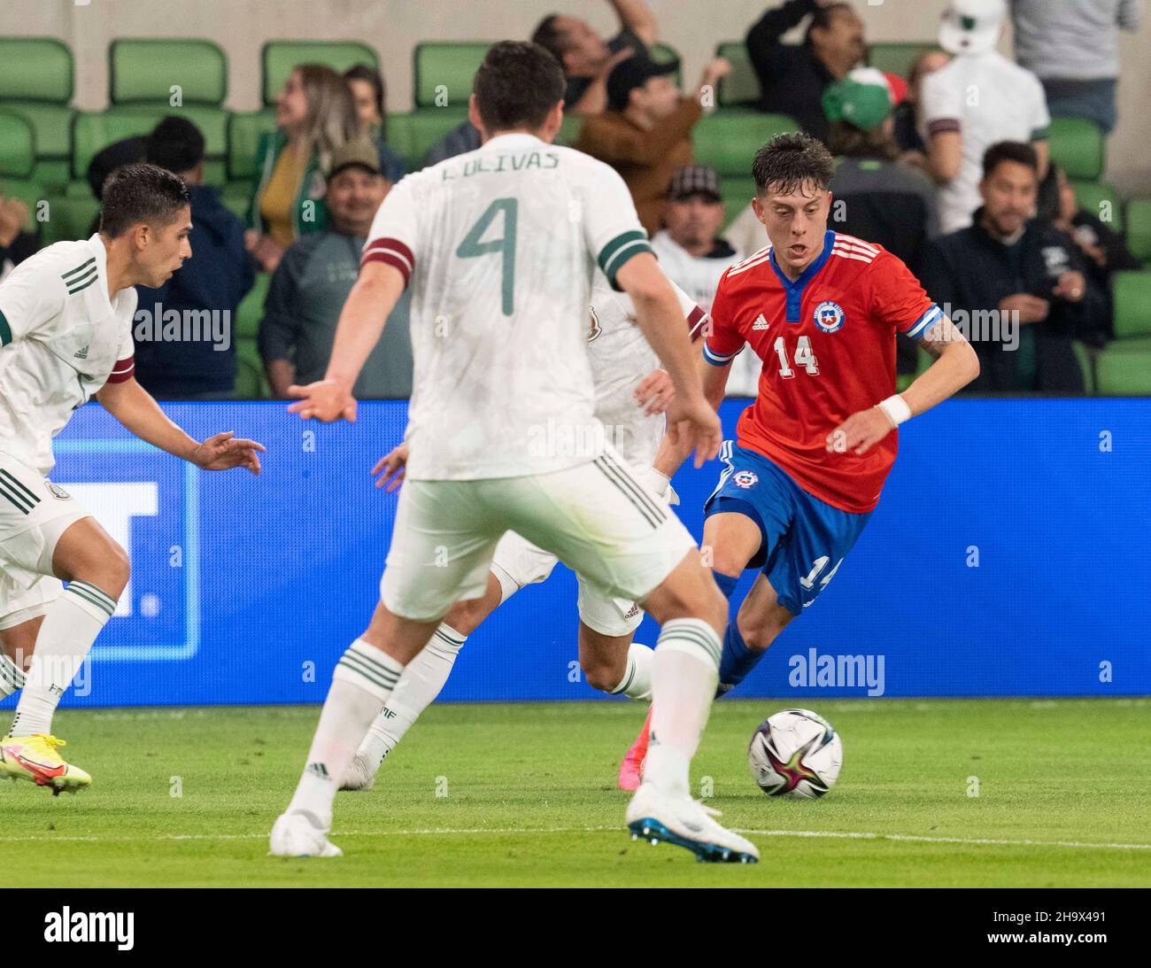 Austin, Texas, USA. 8th December, 2021. PABLO PARRA (14 in red) of Chile tries to work around LUIS SALCEDO (4) of Mexico during the first half of a Mexico National Team vs. Chile friendly at Austin's Q2 Stadium. The teams were tied, 2-2 after regulation play. Credit: Bob Daemmrich/Alamy Live News Stock Photo