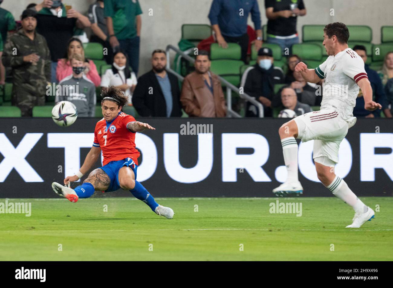 Austin, Texas, USA. 8th December, 2021. Chile's #7 JOAQUIN MONTECINOS takes a shot on goal as Mexico's #4 LUIS SALCEDO, r, tries to defend in the first half of a Mexico National Team vs. Chile friendly at Austin's Q2 Stadium. The teams were tied, 2-2 after regulation play. Credit: Bob Daemmrich/Alamy Live News Stock Photo