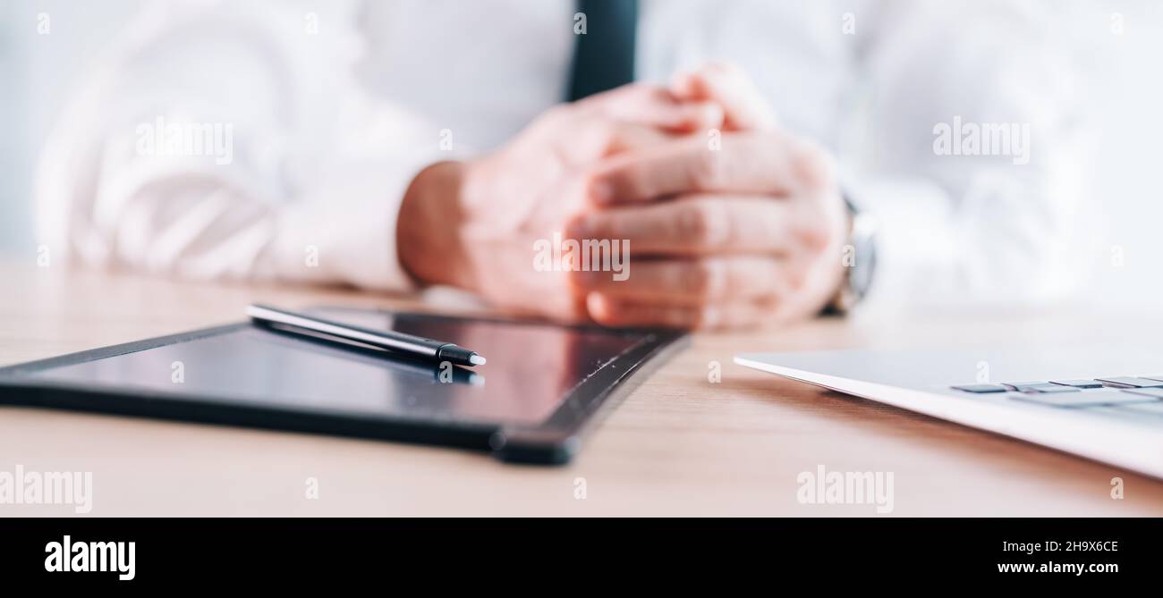 E-signature stylus and pad on business office desk, hands of a businessman in background, panoramic image with selective focus Stock Photo