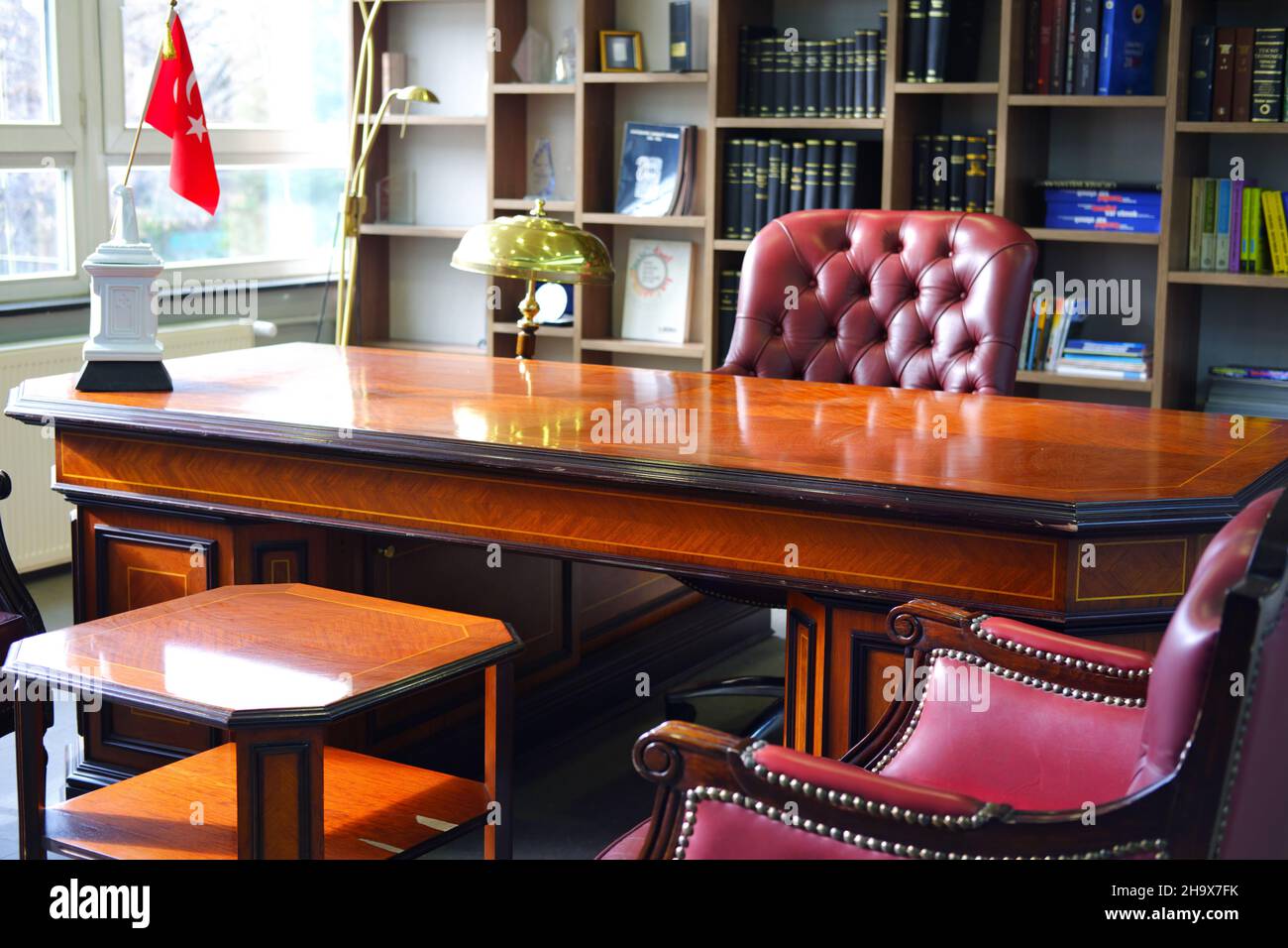 Vintage Boss Desk and Leather Chair with Bookshelf at the Background Stock Photo