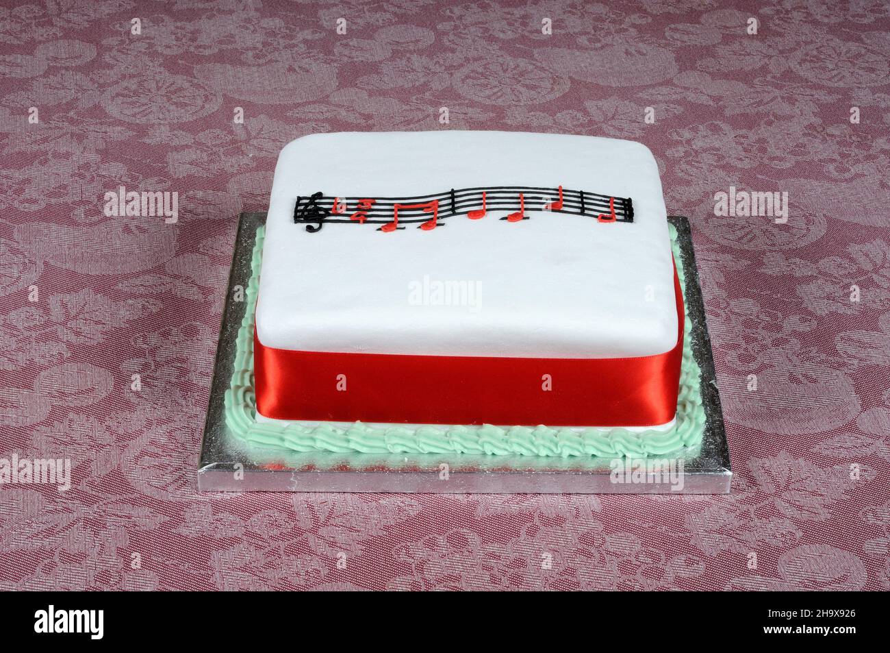 Happy Birthday music atop a square white cake Stock Photo