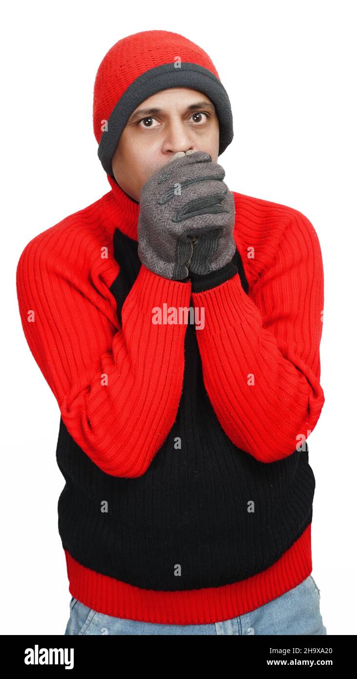 Young Indian Man Wearing a Woolen Cap, Sweater and Hand Gloves, Winter Season, Red and Black Sweater and Cap, Grey Hand Gloves, isolated in White Back Stock Photo